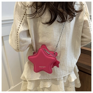 Star-shaped fuchsia crossbody bag with silver chain strap shown on model's back