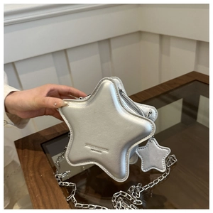 Detail of silver star-shaped crossbody bag with metallic chain and small star charm