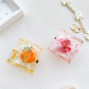 Dettaglio di mini supporti per telefono a forma di fragola e mango realistici
