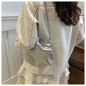 Silver star-shaped crossbody bag with a metal chain strap shown from a back view on a model