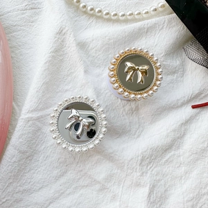 Close-up of pearl-rimmed mirror phone sockets with 3D bow details in gold and silver