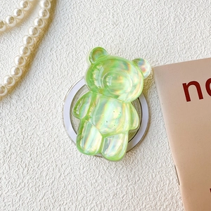 Detail of 3D aurora bear phone grip showing iridescent green finish and round adhesive base