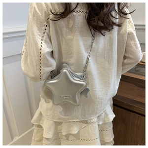 Close-up of matte silver star-shaped crossbody bag with fine metal chain strap