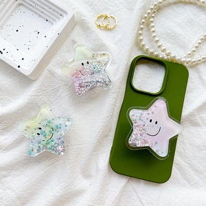 Star-shaped liquid quicksand phone grip with glitter and smiling face on a phone