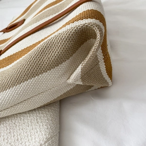 Women's vertical stripe canvas tote bag with brown leather accents and reinforced bottom