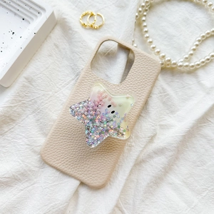 Creamy beige leather phone case with sparkling star-shaped quicksand grip on white fabric