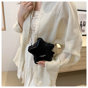 Close-up of black star-shaped crossbody bag with silver chain and white fashion text
