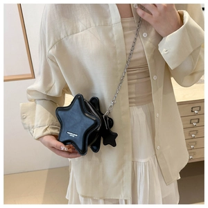 Close-up of star-shaped black leather bag with silver chain strap and metal star charm