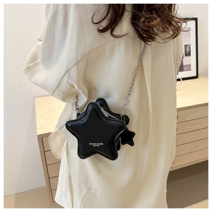 Detail of a black star-shaped crossbody bag with a silver chain and printed logo