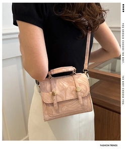 Mannequin portant un sac à main rose texture marbre avec boucles dorées et bandoulière