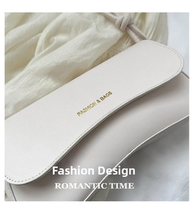 Close-up of cream rectangular flap bag with Fashion & Bags gold lettering and matte leather
