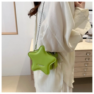 Detail of neon green star-shaped leather bag with silver chain strap and embossed logo