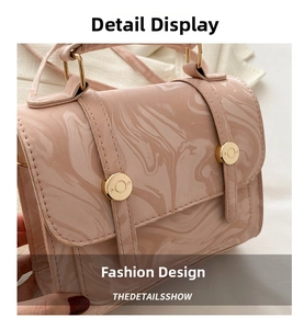 Gros plan sur la texture marbrée et les détails dorés de ce sac à main rose élégant