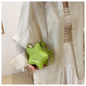 Detail view of lime green star-shaped crossbody bag with silver chain and metal zipper