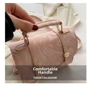 Gros plan du sac à main rose à motif marbre avec boucle dorée et poignée lisse