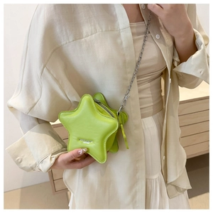 Detail of neon green star-shaped crossbody bag featuring textured leather and silver chain