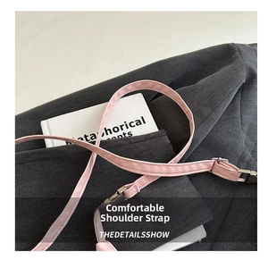 Close-up of pink PU leather adjustable shoulder strap with silver metal buckle on bag