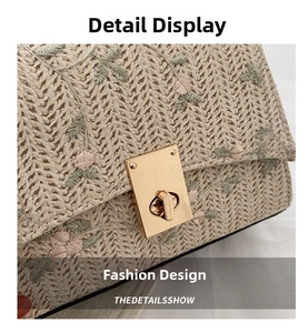 Detail of floral embroidery and golden twist lock on straw square handbag