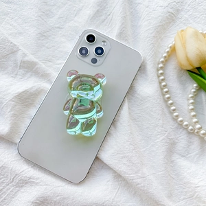 Holographic green bear-shaped collapsible phone grip and stand on white smartphone