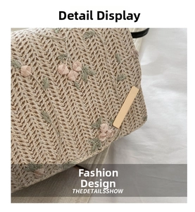 Detailed macro view of woven herringbone fabric with pink floral embroidery and gold hardware
