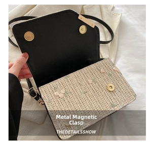 Close-up of golden magnetic snap closure on straw embroidered shoulder bag detail