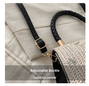 Detail of embroidered straw bag showing the adjustable leather strap and gold buckle