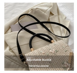 Detail of floral embroidery and adjustable leather strap on woven straw square bag