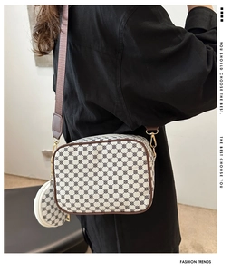 Detail of geometric pattern crossbody bag with brown leather trim and round coin purse