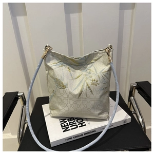 Detailed view of traditional Chinese embroidery and jacquard texture on the shoulder bag