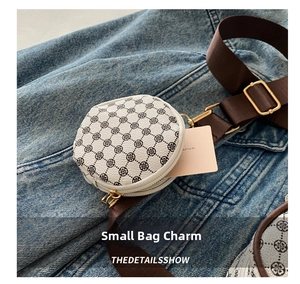 Macro shot of circular mini coin purse with classic check pattern and gold metal hardware