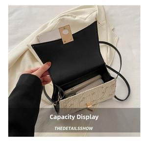 Interior view of straw crossbody bag with floral embroidery and gold hardware detail