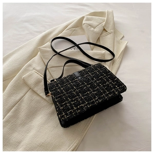 Détails de la texture en tweed noir et doré sur le petit sac à bandoulière en cuir