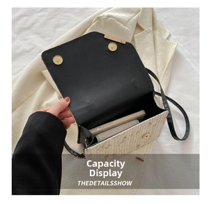 Interior view of straw woven bag with black leather flap showing space for phone