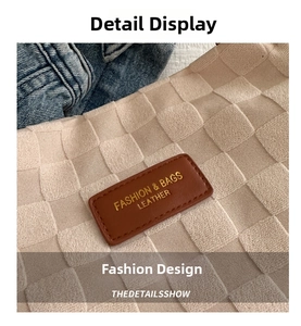 Close-up of beige quilted nylon tote bag with brown leather brand label and gold lettering