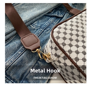 Detail of vintage crossbody bag with geometric pattern, leather trim and gold metal hook