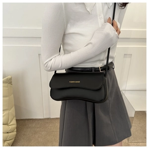 Detail of minimalist black matte leather crossbody bag with gold Fashion & Bags lettering