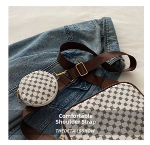 Detail of cream patterned crossbody bag with wide brown strap and round coin purse attachment
