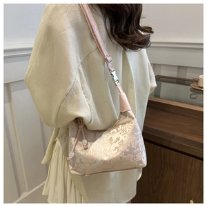 Detail of vintage floral embroidery on light pink jacquard bucket bag with pearl drawstring