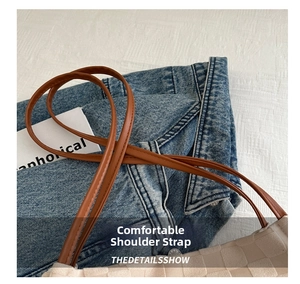 Detail of soft leather shoulder strap on a beige woven tote bag with stitching detail