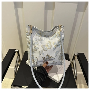 Detailed shot of golden butterfly embroidery on high-density jacquard fabric shoulder bag