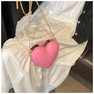 Pink heart-shaped hard shell crossbody bag with gold metal trim and chain strap