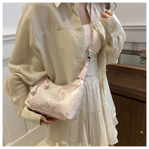 Detail of pink jacquard bucket bag with landscape pattern and silver metal buckle