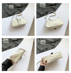 Vista dettagliata di una borsa a tracolla patchwork crema con fibbia argento e cuciture