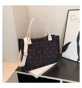 Detail of strawberry print corduroy tote showing dual front pockets and texture