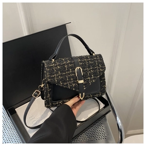 Détail de la texture élégante en tweed noir et cuir sur un petit sac à main à bandoulière chic