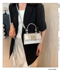 Detail view of the silver stone pattern faux leather handbag with a metal handle and strap