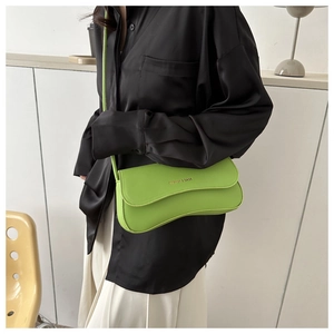 Detail of a bright green irregular crescent shoulder bag with FASHION & BAGS logo