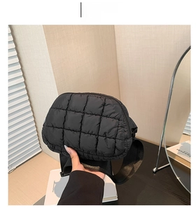 Détail de la sacoche matelassée noire à carreaux avec une large bandoulière en nylon