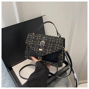 Détail du sac à main de luxe en tweed noir avec boucle en métal doré et bandoulière