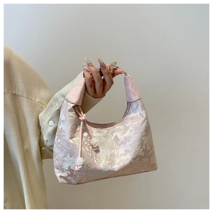 Detail of pink brocade satchel featuring classic Chinese pavilion patterns and bead charms